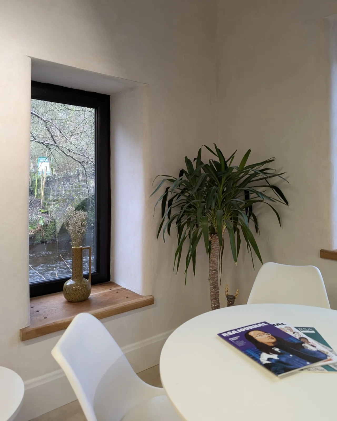 A corner of the reconfigured Crown Works office with a round table by the window